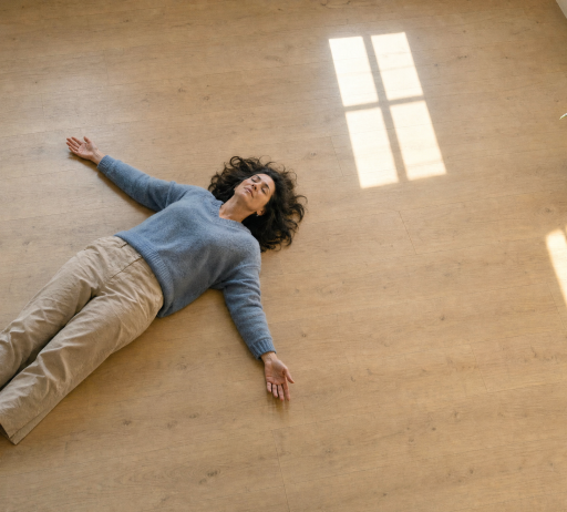 Mujer tumbada en el suelo respirando con calma, psicología para adultos en Lazos