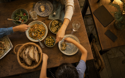 Mesa de cena familiar vista desde arriba con el móvil y la tablet apagados en una estantería - blog de Clínica Lazos